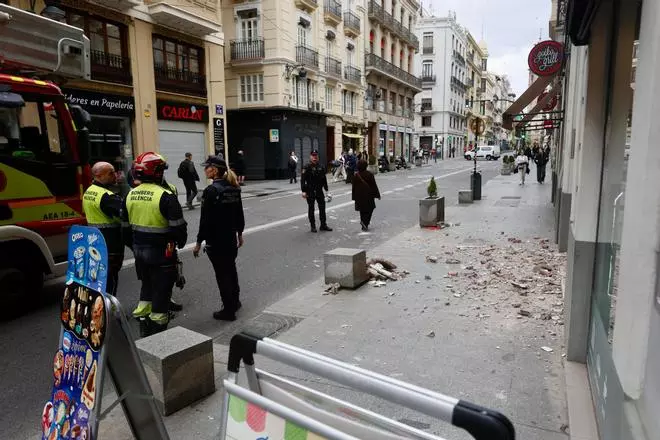 Cae parte de una fachada en plena calle de la Paz de València
