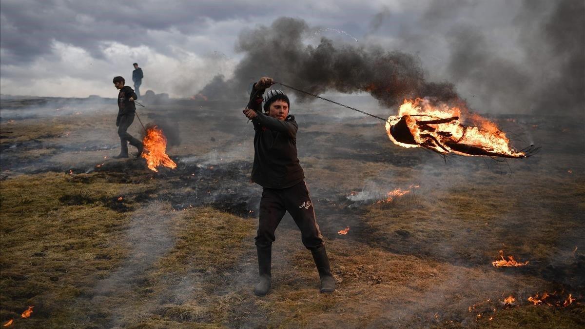 Un joven gira un neumático en llamas como parte de una tradición que marca el  Lunes Limpio, primer día de la Gran Cuaresma en el calendario de la iglesia cristiana ortodoxa oriental.