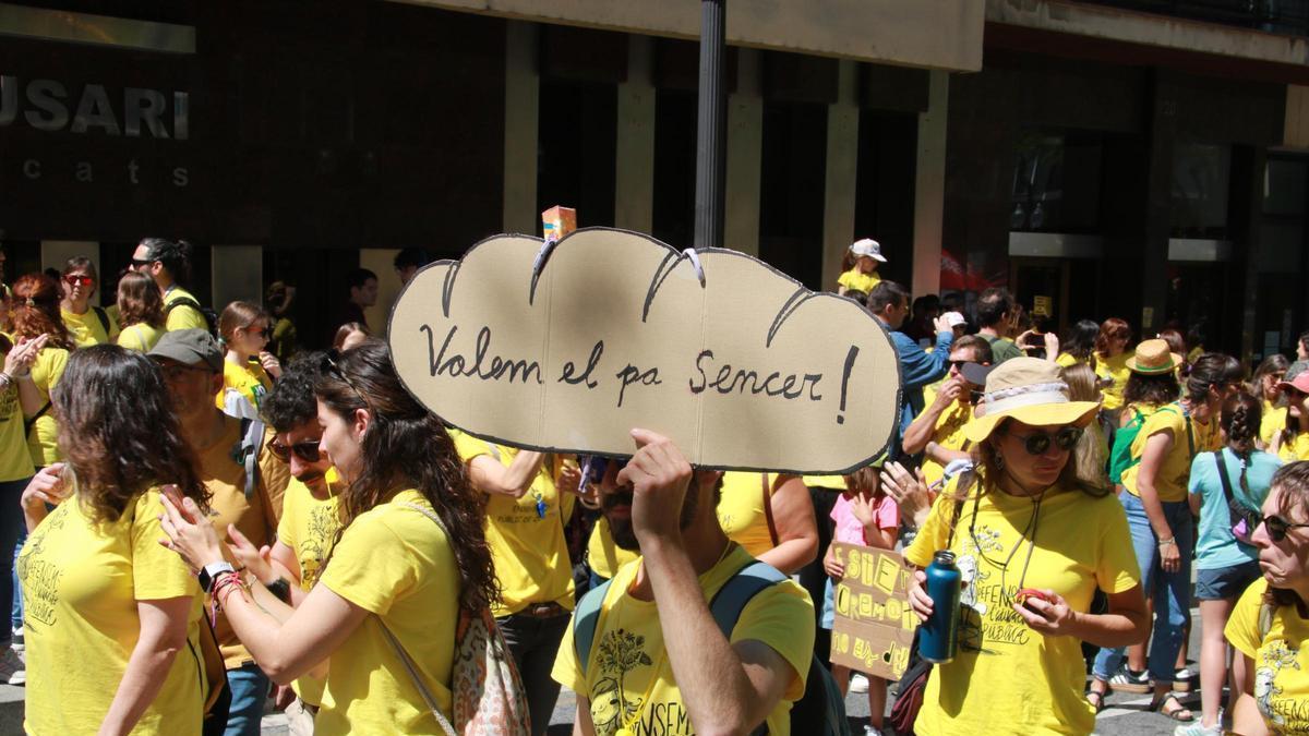 Docents i professionals de la comunitat educativa amb un cartell reivindicatiu en la manifestació de Tarragona