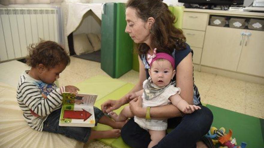 Palacios a casa seva, que és llar de criança, amb la Noa (als braços) i el Dani, dos dels infants que educa