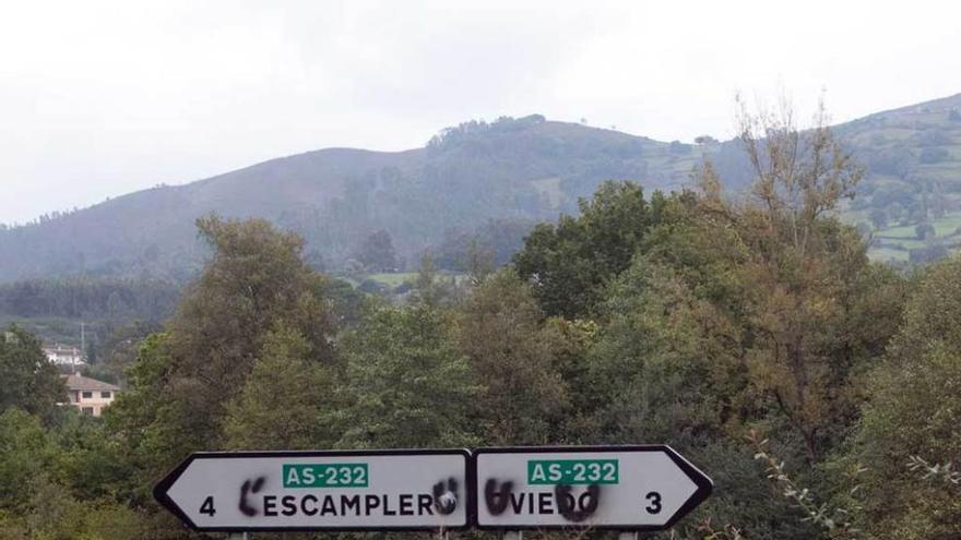 Señales con pintadas reclamando los topónimos en asturiano.