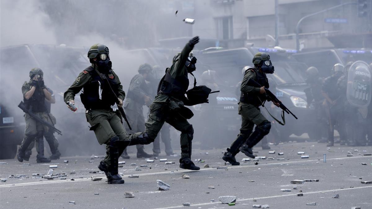 Policías lanzan botes de gas lacrimógeno contra los manifestantes que les lanzaron piedras y latas en las inmediaciones del Congreso, en Buenos Aires, el 14 de diciembre.