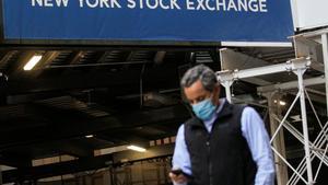 A New York Stock Exchange employee uses his phone on Wall St. outside the New York Stock Exchange (NYSE) in New York City, New York, U.S., November 9, 2020. REUTERS/Brendan McDermid