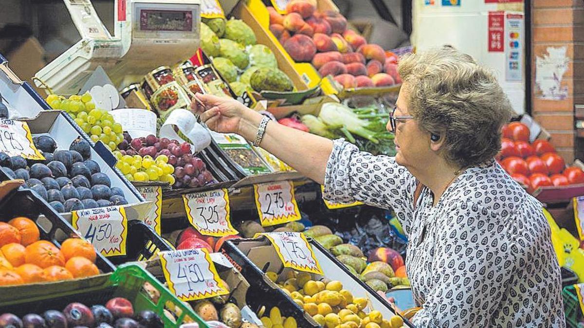 Una mujer comprando fruta en un mercado cordobés.