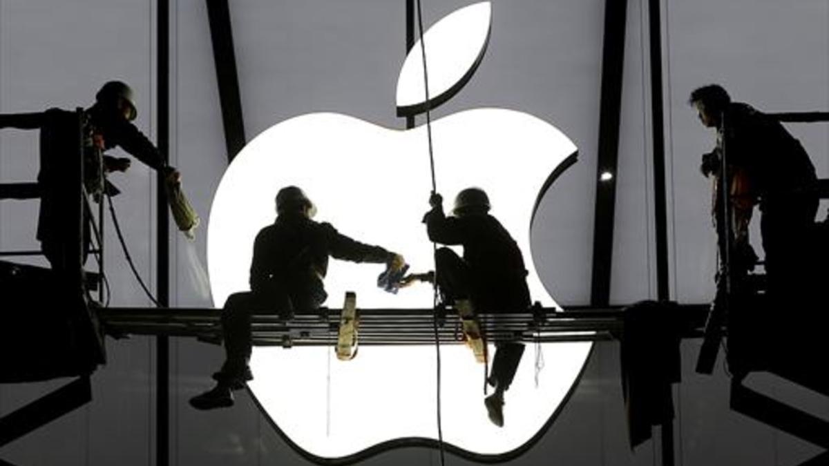 Varios operarios ultiman los trabajos antes de la apertura de una nueva tienda de Apple.