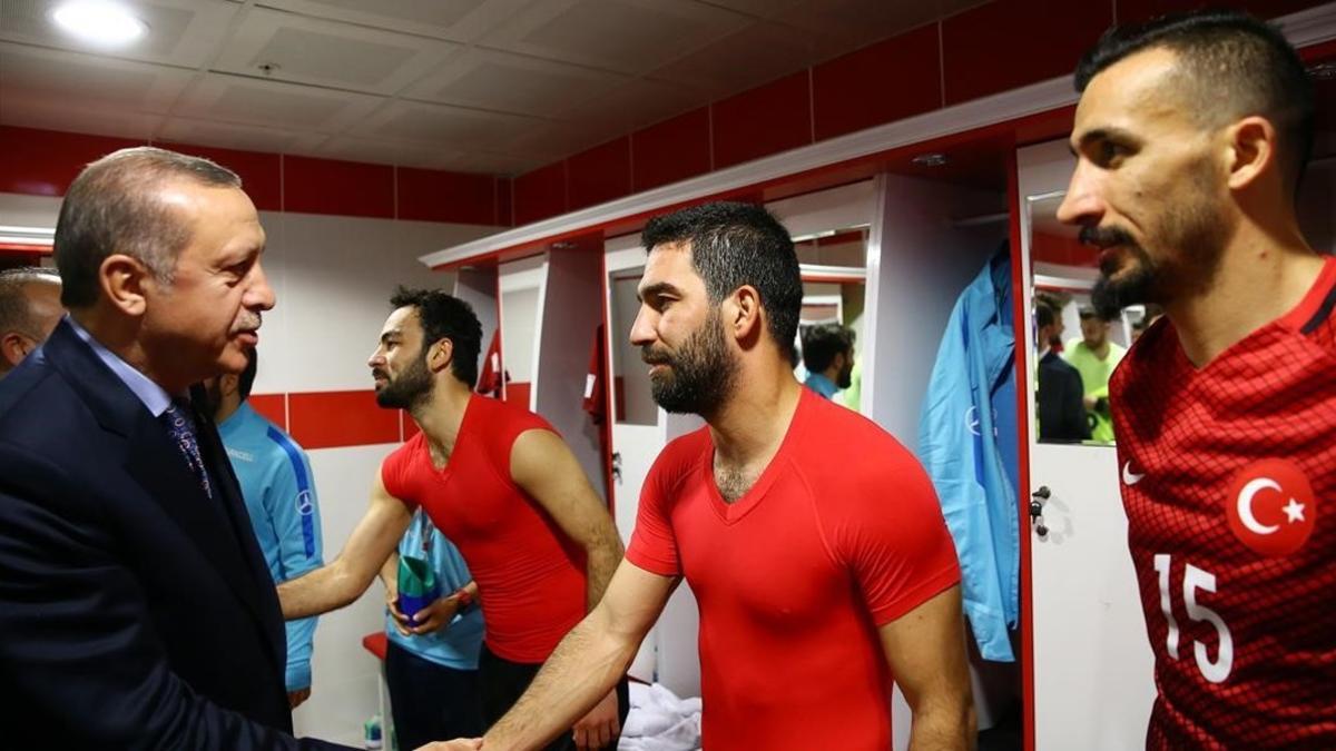 Erdogan, el presidente turco, saluda a Arda Turan en el vestuario tras el duelo con Finlandia.