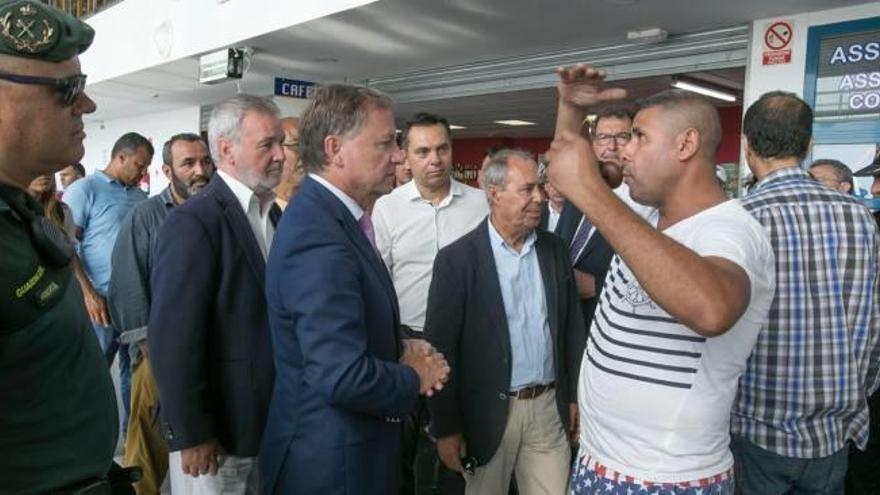 El delegado del Gobierno, Juan Carlos Moragues, escucha las críticas de un pasajero por el calor y la falta de zona de sombra.