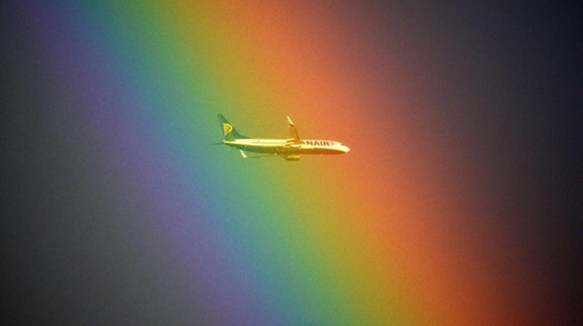 Un avión pasa frente a un arco iris en Roma.
