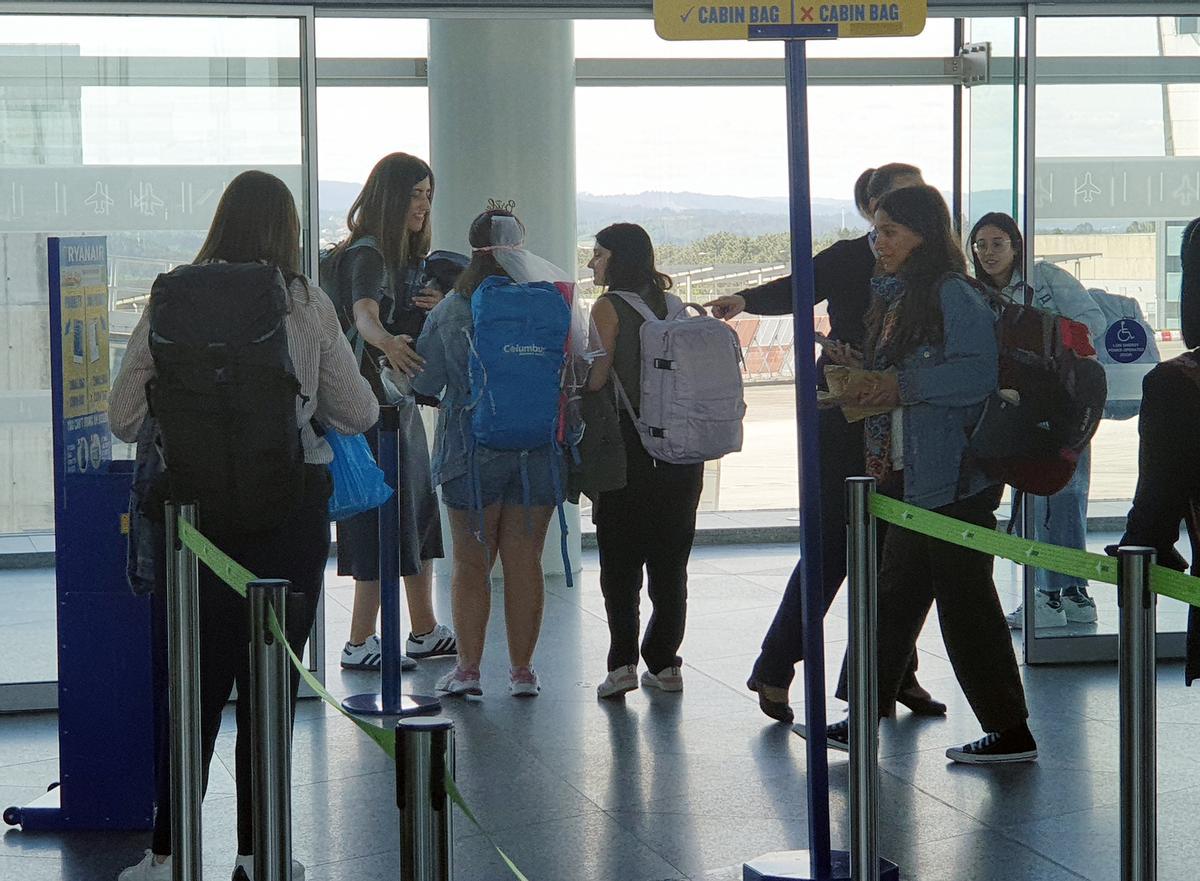 Un grupo de personas esperan en la puerta de embarque en el aeropuerto de Santiago