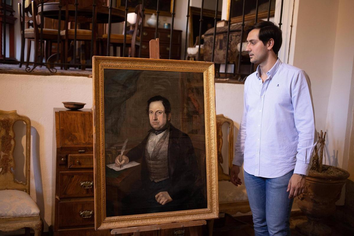 El anticuario Luis Llorens, junto al retrato atribuido a Ramón Simarro.