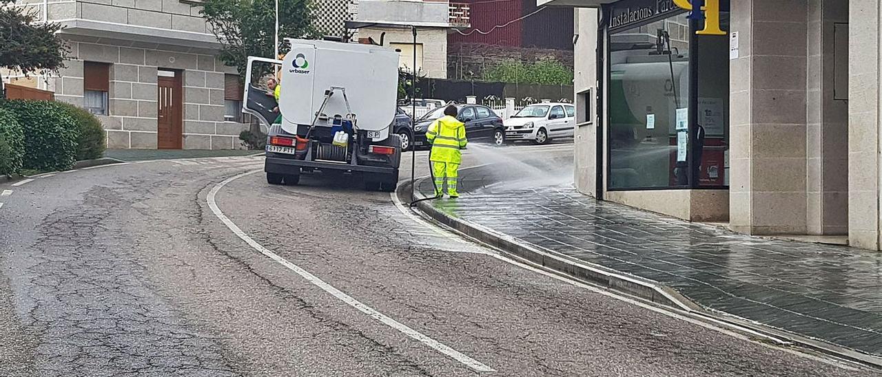 Operarios del servicio de limpieza viaria baldeando una calle en Moaña. |   // FDV