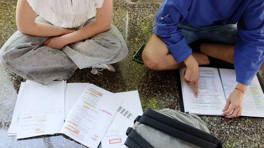 Estudiantes repasando apuntes antes de un examen.