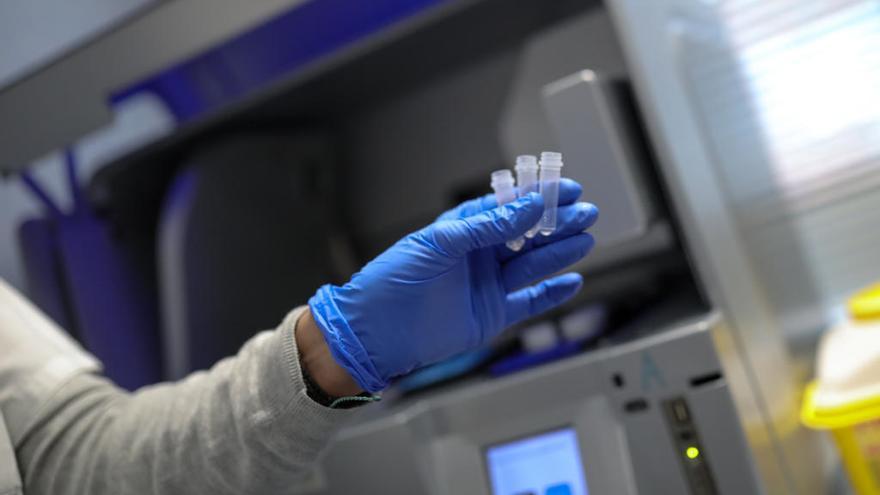 Una trabajadora con guantes muestra tres cápsulas en el Centro Nacional de Microbiología, en Majadahonda.