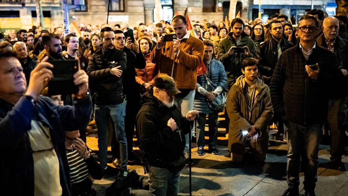 Varias personas rezan frente a la sede del PSOE en la madrileña calle de Ferraz, en una protesta.