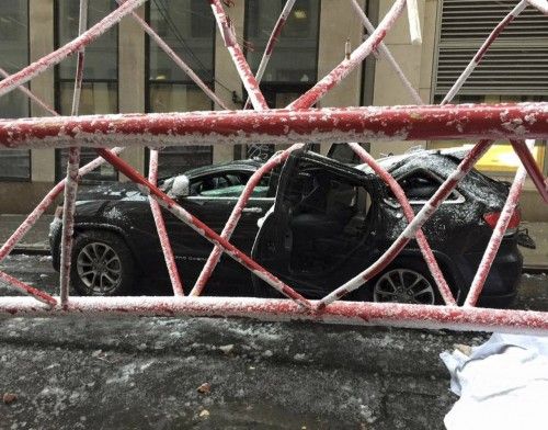 A car is seen crushed by a massive construction crane collapse on a street in downtown Manhattan in New York