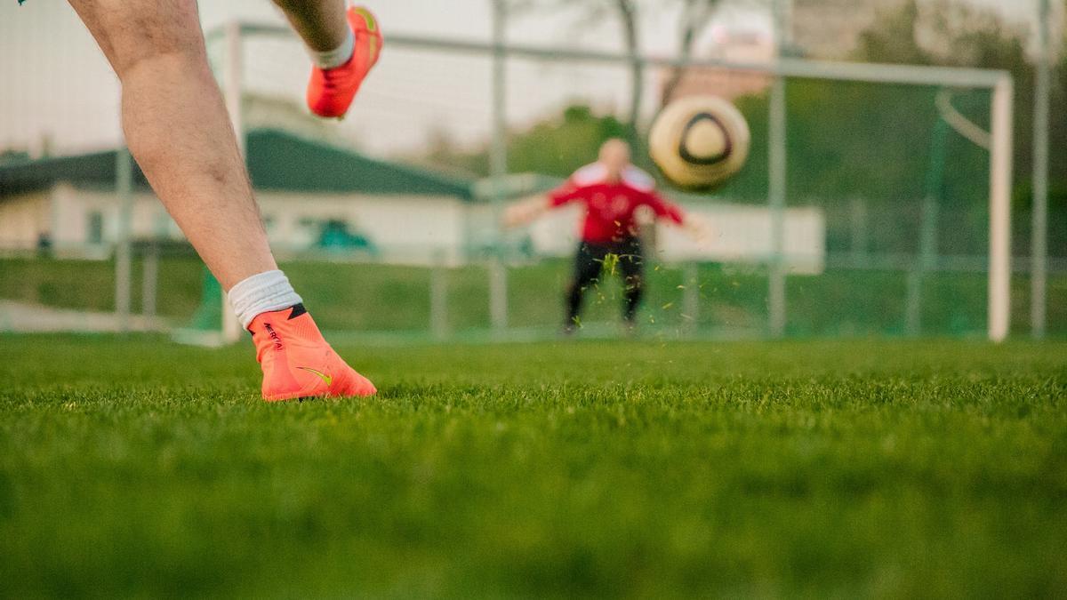 Un futbolista golpeando a portería.