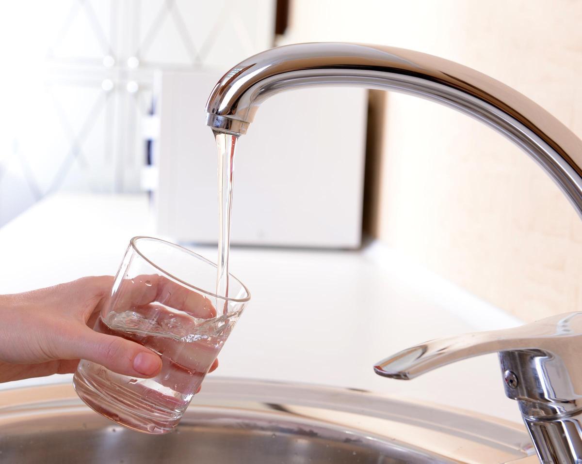 Agua saliendo del grifo en una casa