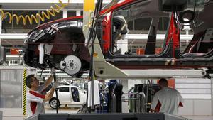 A worker from the SEAT factory, under the Volkswagen group, works on an engine of a SEAT Leon car, in Martorell near Barcelona