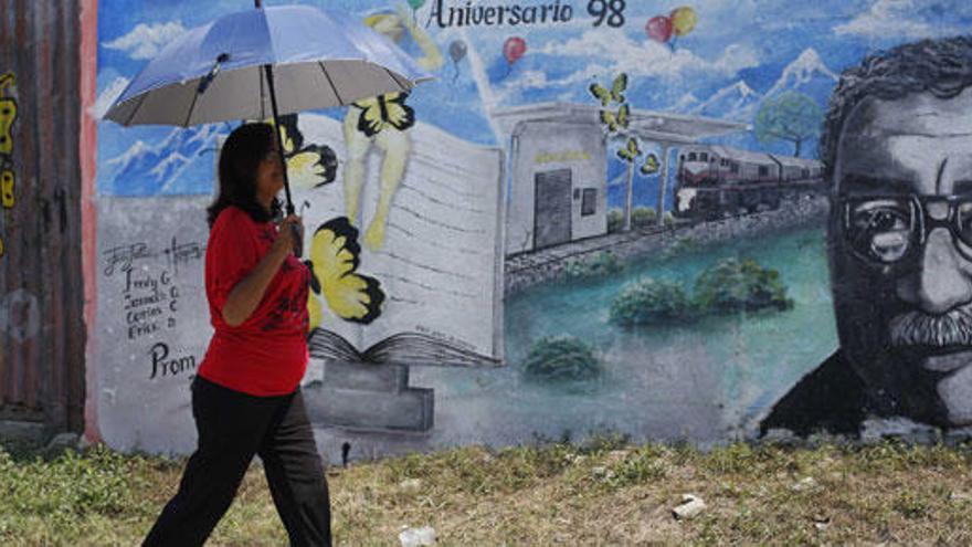 Una mujer pasa delante de un mural de García Márquez.