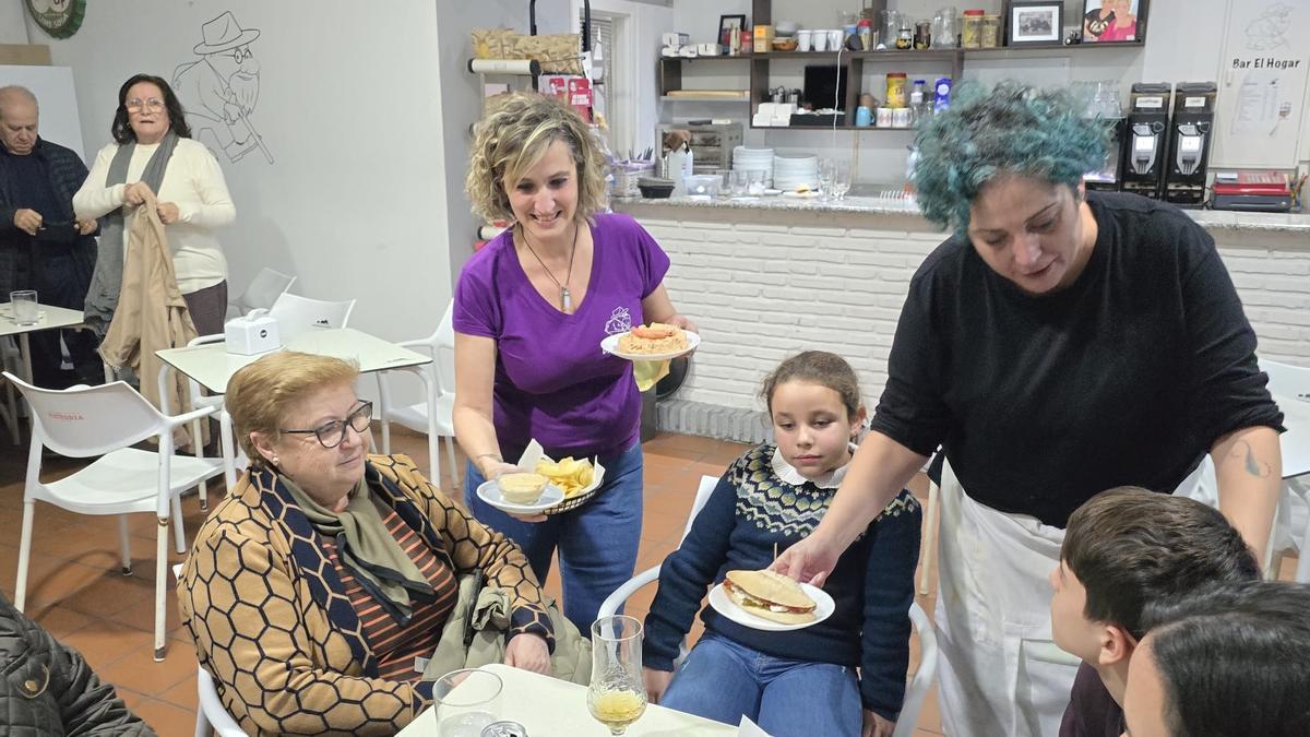 Vecinos reciben varias de las tapas en uno de los bares de El Carpio.