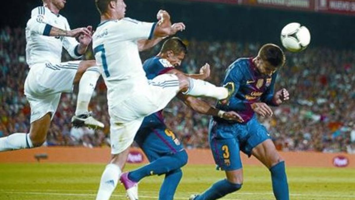 Piqué remata de cabeza un saque de córner ante Ronaldo y Sergio Ramos.