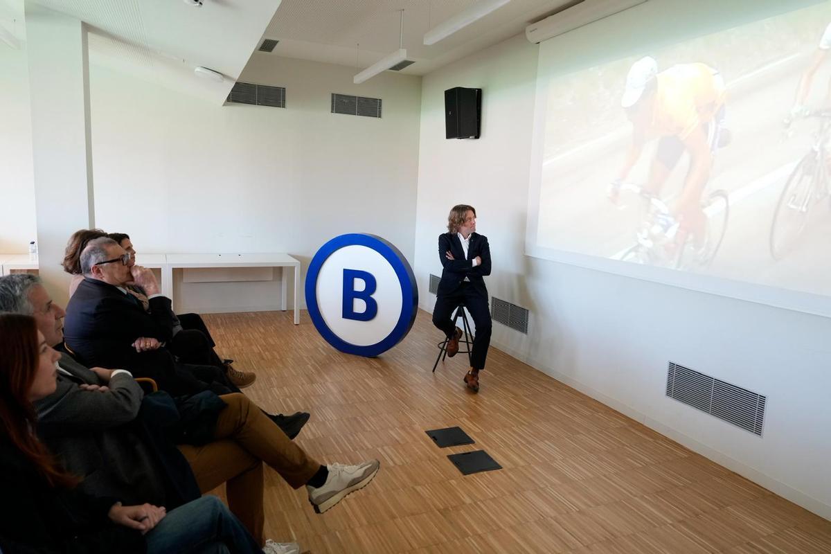 El concejal de Deportes de Barcelona, David Escudé, observa un vídeo con Miguel Induráin enfundado de amarillo durante el acto de Barcelona Global.