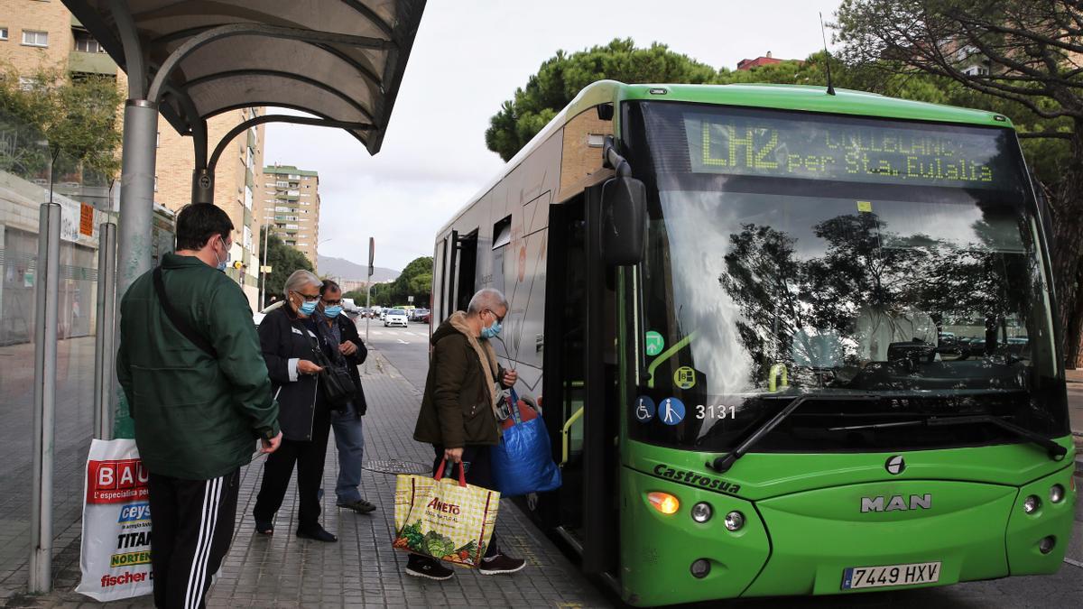 Pasajeros suben a un autobús de Rosanbus en la avenida Carmen Amaya de L'Hospitalet de Llobregat.