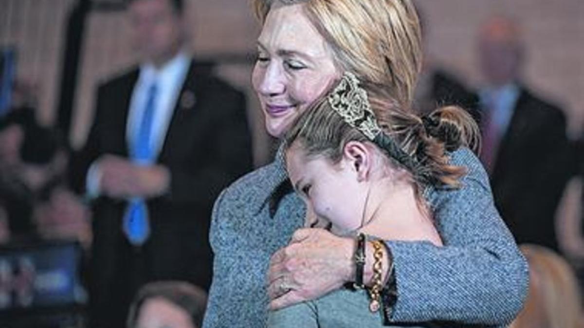 Hillary Clinton abraza a una niña en su sede electoral