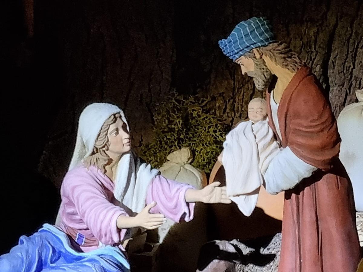 Nacimiento con San José sosteniendo a Jesús.