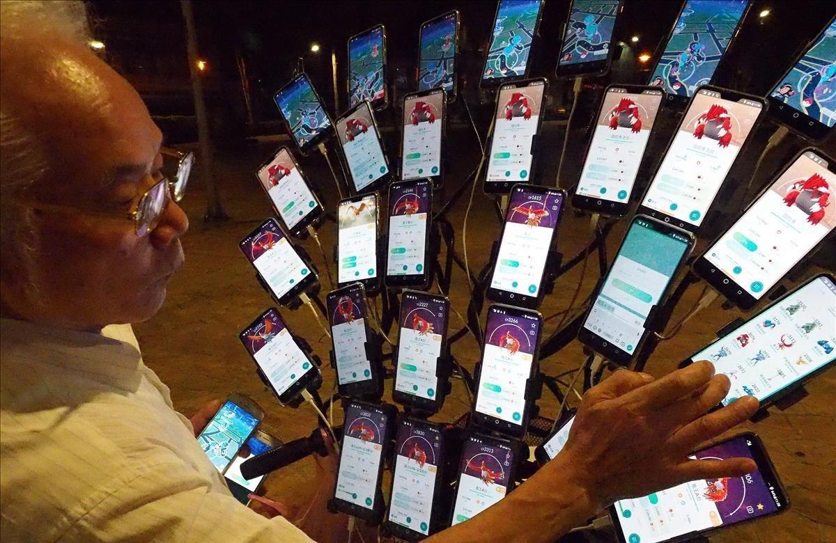 Chen San-yuan, maestro de Feng Shui de 70 años, utiliza 29 teléfonos móviles en su bicicleta mientras juega al juego Pokémon Go, este martes en Nuevo Taipéi, Taiwán.