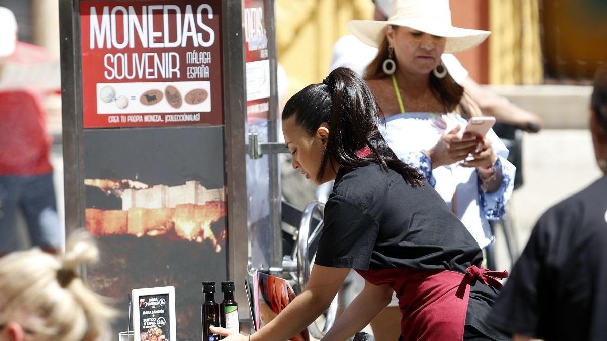 Una camarera sirve a unos turistas en un bar del Centro Histórico.