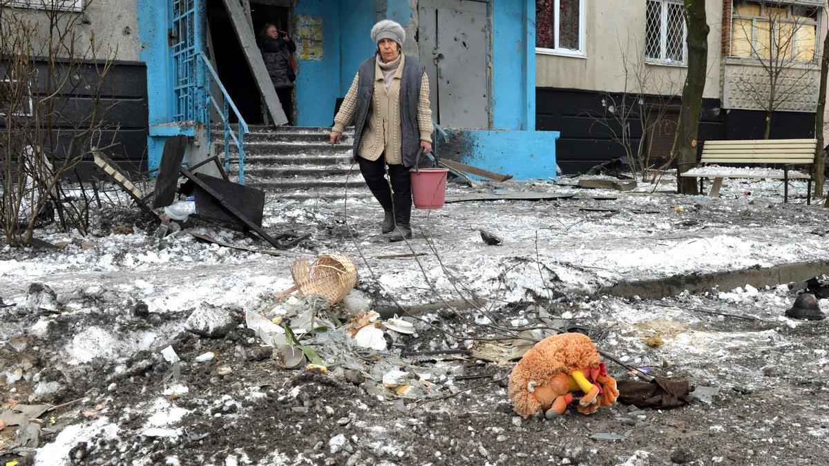 Una mujer lleva un cubo tras un bombardeo en Kharkiv, la segunda ciudad más grande de Ucrania, el 7 de marzo de 2022.