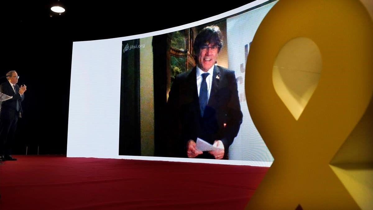 Torra escucha una intervención de Puigdemont por videoconferencia, en el mitin final de campaña de JxCat de las últimas elecciones generales, en Barcelona.