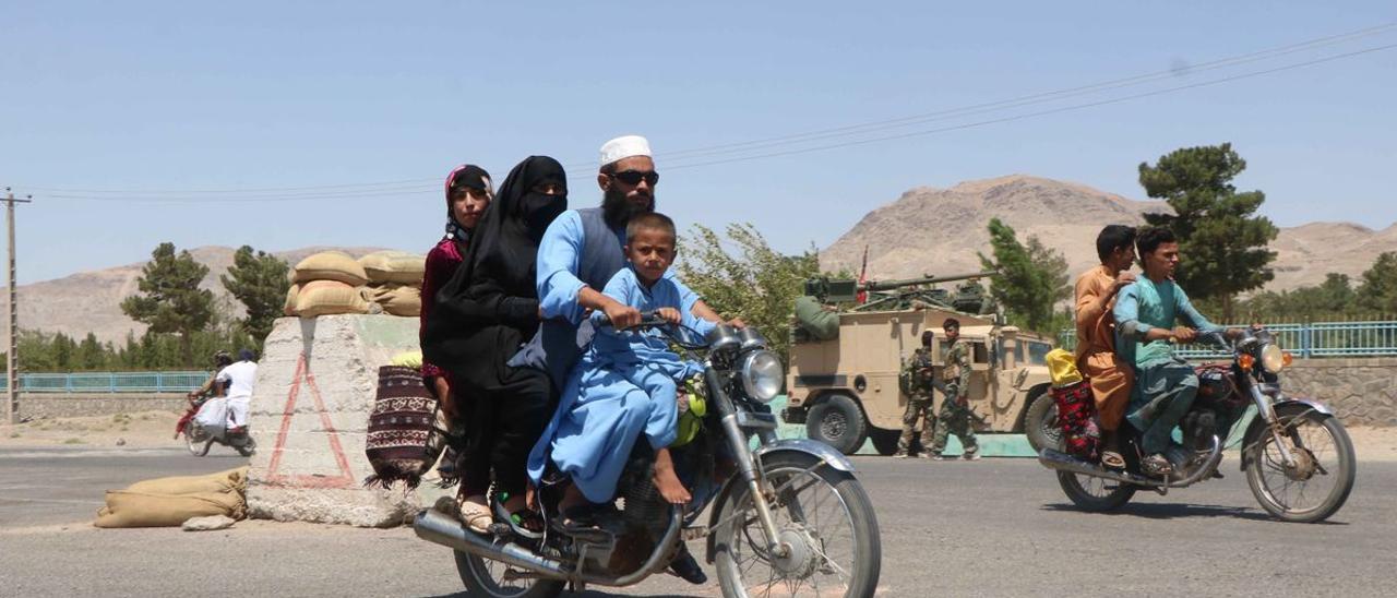Una familia afgana pasa fente a las fuerzas de seguridad en una de las entradas de Herat.