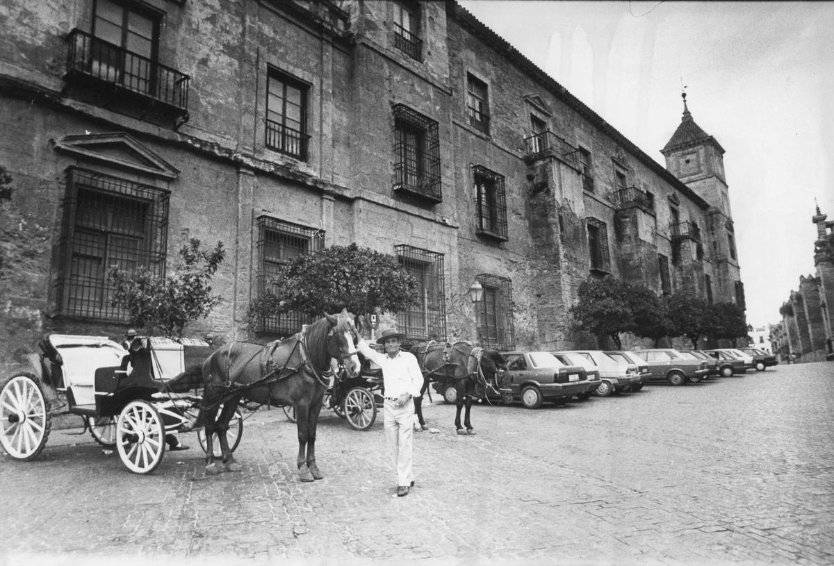 Carruajes de caballos y vehículos aparcados en Torrijos, frente al palacio.