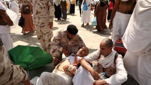 Un hombre peregrino afectado por el calor abrasador recibe ayuda de un miembro de las fuerzas de seguridad saudíes en La Meca. 