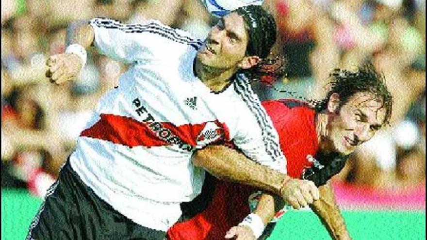 Sebastián Abreu, del River, disputa de cabeza un balón con Schiavi, de Newell&#039;s.