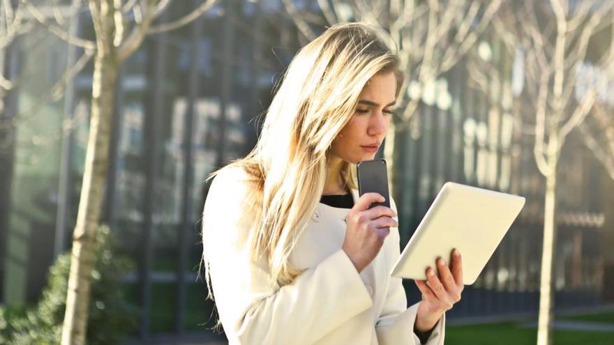 Una estudiante, con su móvil y su tablet