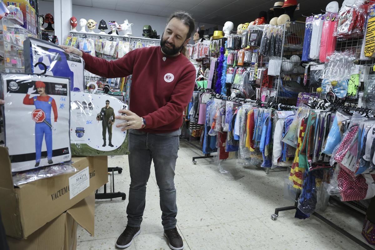 Un comerciante muestra varios disfraces en su tienda.