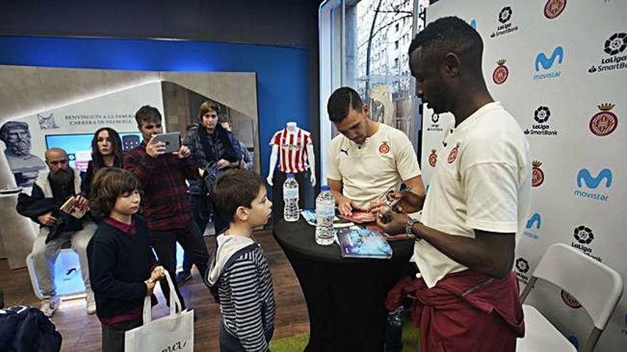 Gallar i Diamanka signant ahir autògrafs a dos joves aficionats del Girona.