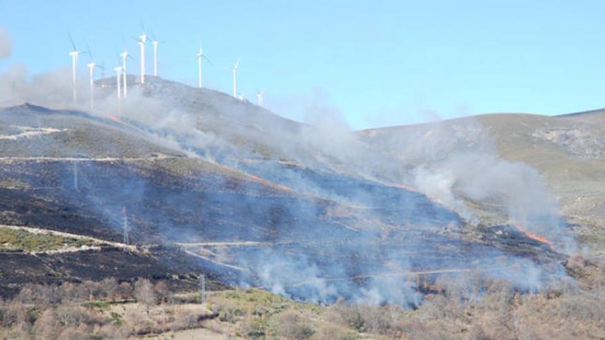 Avance del incendio a lo largo del valle del Tuela en la ladera de Chanos, con el parque eólico en lo más alto.