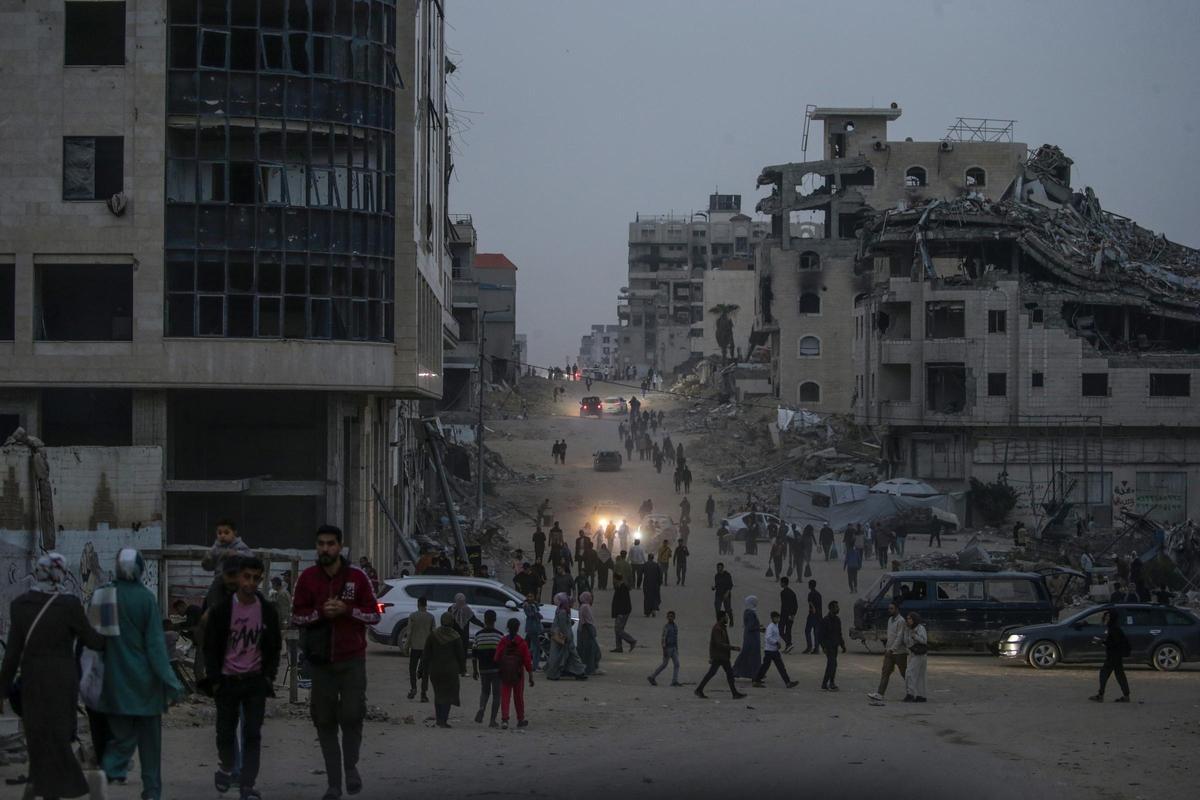 Palestinos desplazados internos caminan por una calle de la Ciudad de Gaza, este martes.