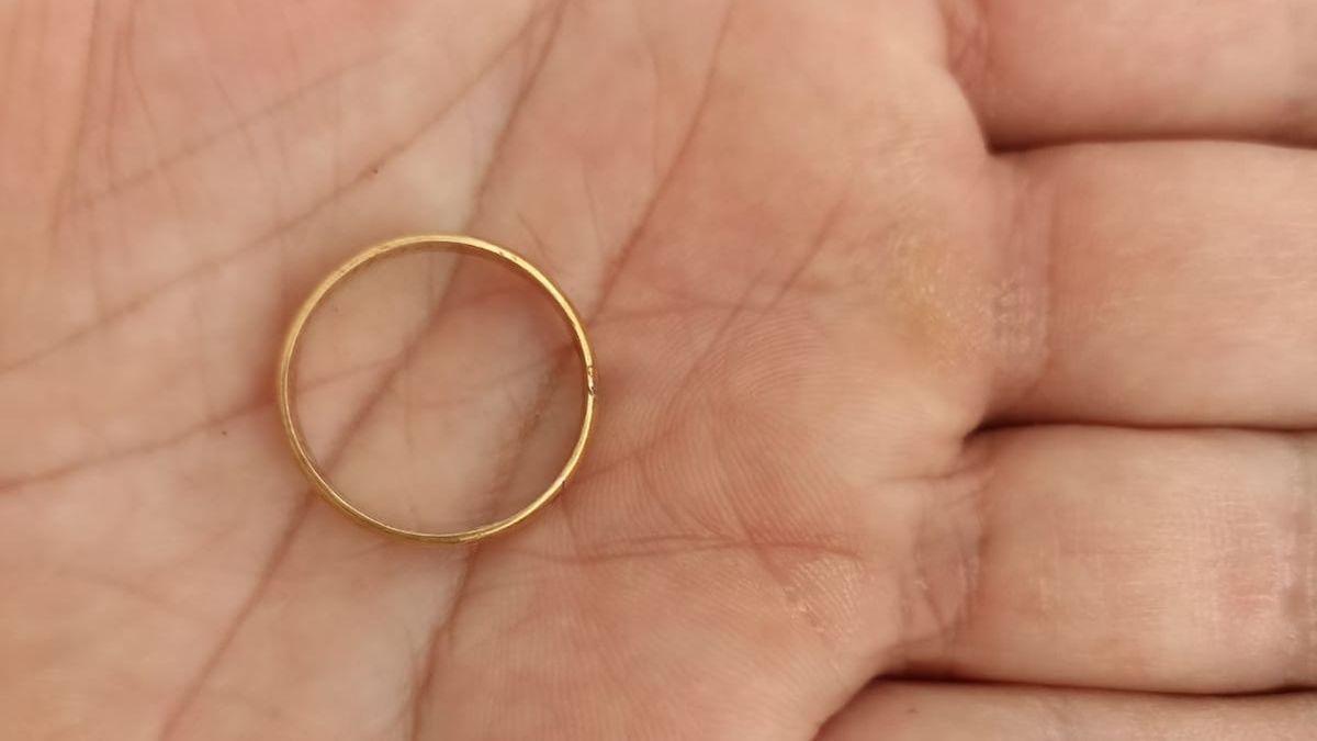 El anillo de boda de 1907 en las manos de uno de los arqueólogos que han exhumado la fosa.