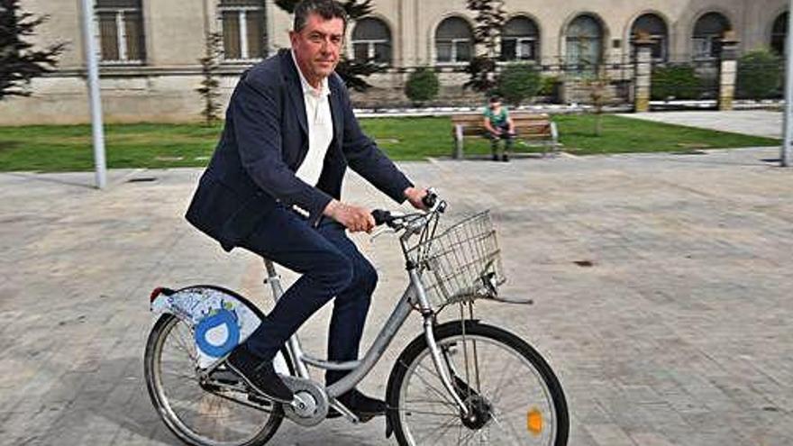 El concejal de Deportes Juan Ignacio Borrego, ayer, subido a una bicicleta de Bici Coruña en la Marina.