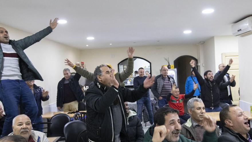 Membres de la comunitat marroquina de Figueres seguint el partit entre la seva selecció i Espanya en un bar del carrer Pere III.