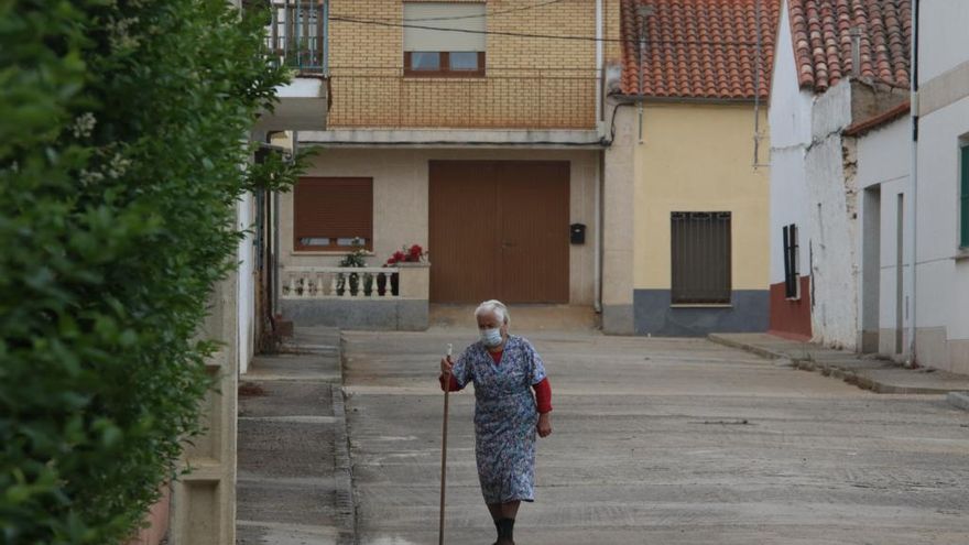 Una mujer pasea por un pueblo.