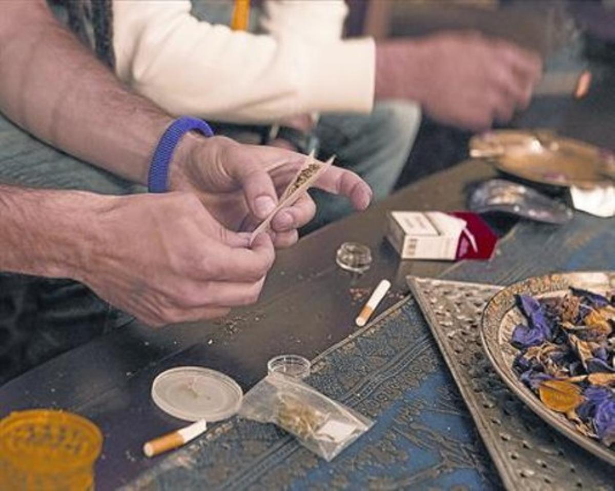 Un usuari es prepara un porro en un club del carrer de Nàpols de Barcelona, dilluns. Un usuari es prepara un porro en un club del carrer de Nàpols de Barcelona, dilluns.