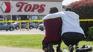 Una pareja arrodillada en las cercanías del supermercado de Búfalo donde se produjo la matanza.