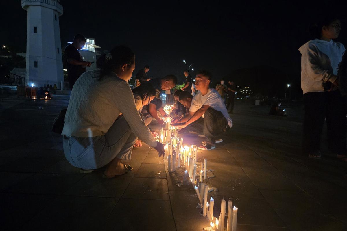 FOTODELDÍA LABUAN BAJO (INDONESIA), 02/01/2026.- Unas personas participan en una vigilia tras la misión de búsqueda de este viernes de los tres españoles desaparecidos en aguas de Indonesia. La Policía de Indonesia ha abierto una investigación para determinar si se incurrió en algún delito en el naufragio el viernes de la semana pasada de un barco turístico con seis españoles a bordo, una de las cuales falleció mientras tres continúan desaparecidos tras ocho días de búsqueda. EFE/ Noel Caballero