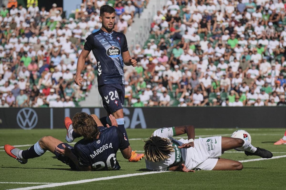El céltico Carlos Domínguez observa a su compañero Marcos Alonso y a un jugador del Elche, ambos en el suelo.